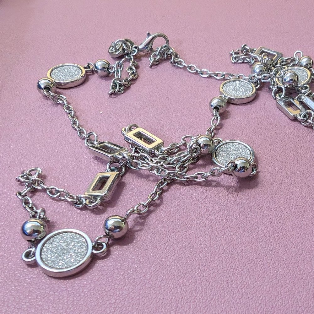 Long silver necklace with metallic accents